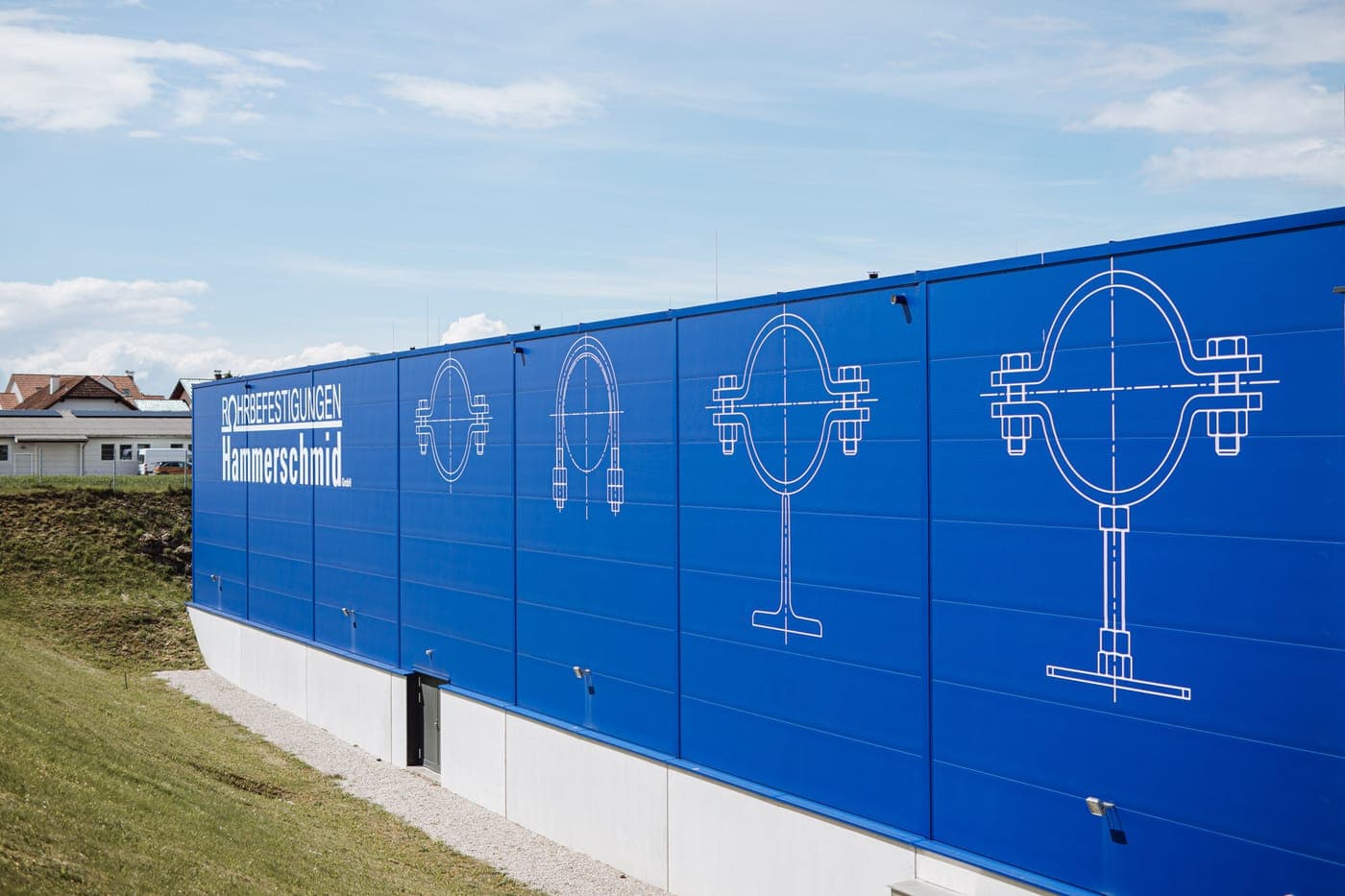 Fassade des Hammerschmid-Werks in Marchtrenk mit technischen Zeichnungen von Rohrbefestigungen